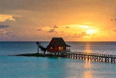 Red stilt house on pier at sunset