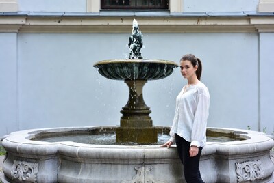 Woman standing by ornate fountain