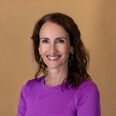 Smiling woman in purple top with star earrings