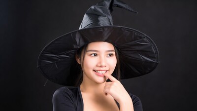 Asian woman in witch hat smiling