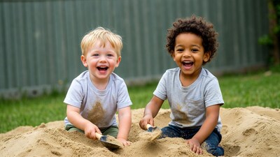 Two boys playing with shovels in sand