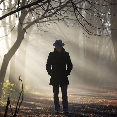 Man in hat standing in foggy forest