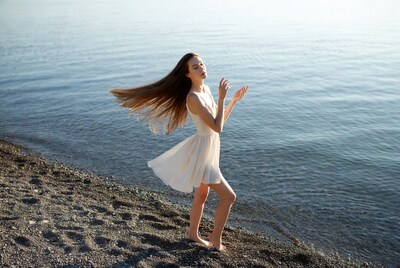 Woman dancing on beach by lake