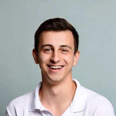 Young man smiling in white polo shirt