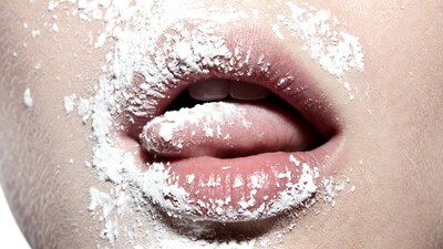 Woman's tongue out with powdered sugar