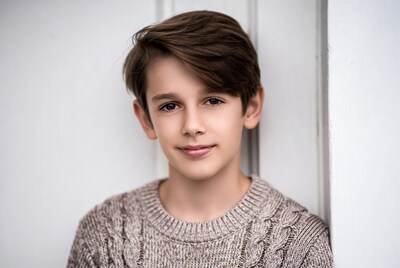 Boy smiling against white wall