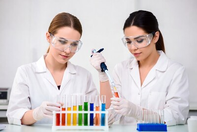 Women scientists using pipettes with test tubes