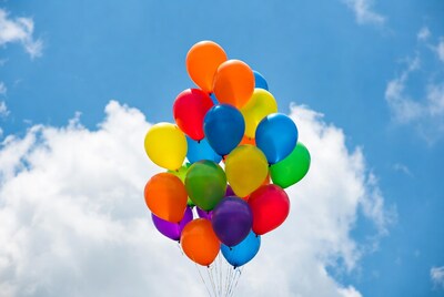 Colorful balloons floating in blue sky