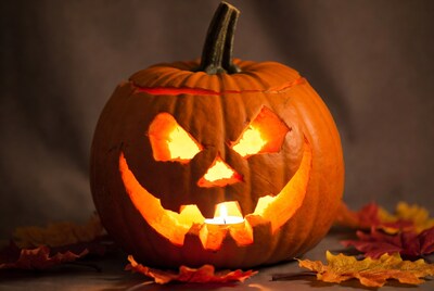 Lit Jack-o'-lantern with fall leaves