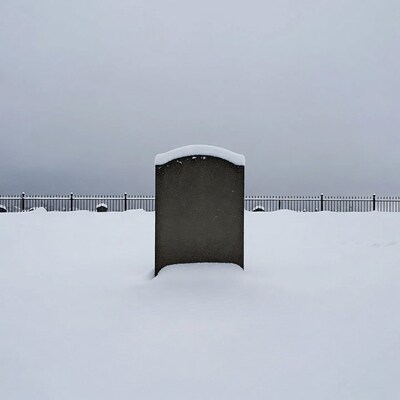 Snowy gravestone in cemetery