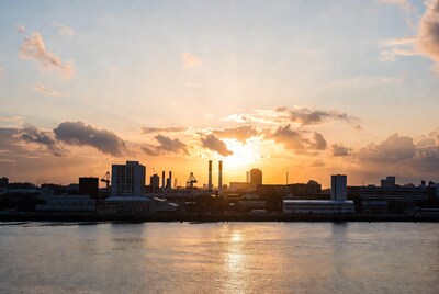 Industrial city skyline at sunset over river