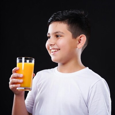 Boy holding orange juice glass