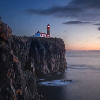 Red Lighthouse on Cliff at Twilight