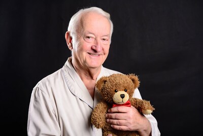 Elderly man holding teddy bear