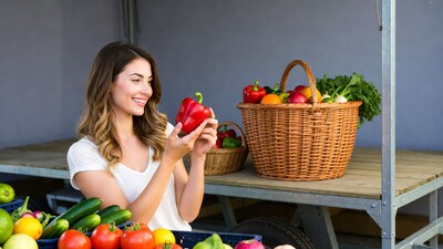 Woman holding red bell pepper at market