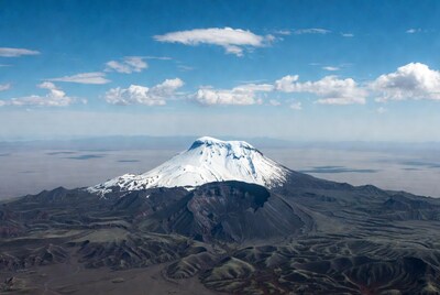 Snow-capped volcano in rugged landscape