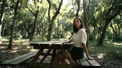Woman sitting on picnic table in forest