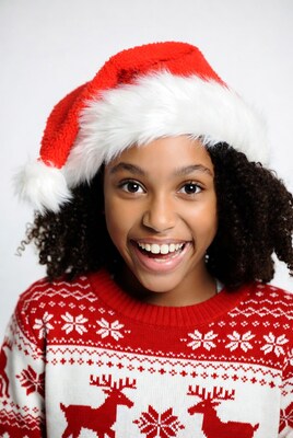 African-American girl in Santa hat smiling