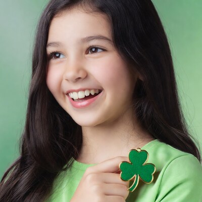 Girl holding green shamrock pendant