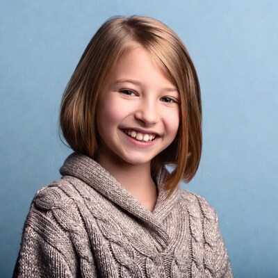 Smiling girl in sweater on blue background