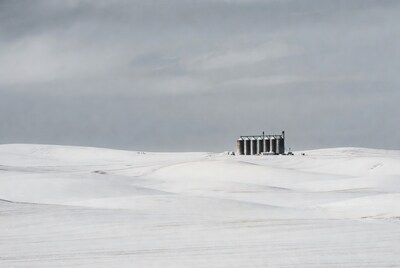 Grain Silos on Snowy Field