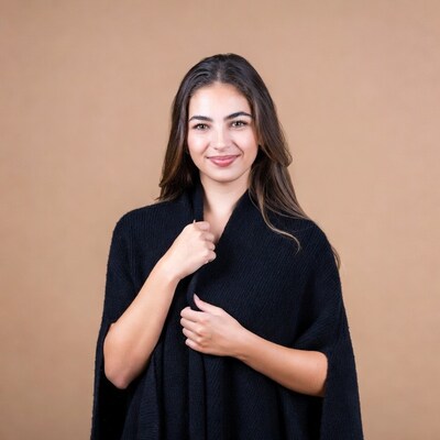 Woman holding black knit poncho