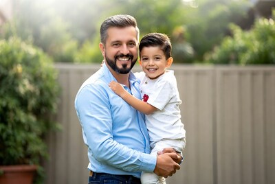 Father holding smiling son outdoors
