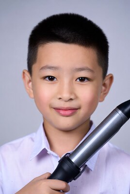 Asian boy holding curling iron