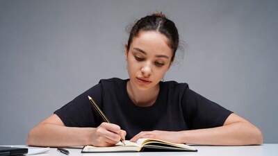 Woman writing in notebook at desk