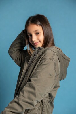 Girl smiling in hoodie on blue background