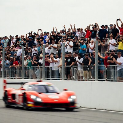 Red Race Car Speeds Past Cheering Crowd