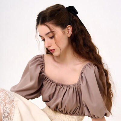 Woman in brown off-shoulder top with bow
