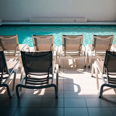 Empty pool chairs by turquoise pool