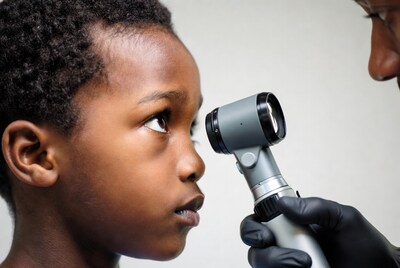 Doctor examining boy's eye with ophthalmoscope