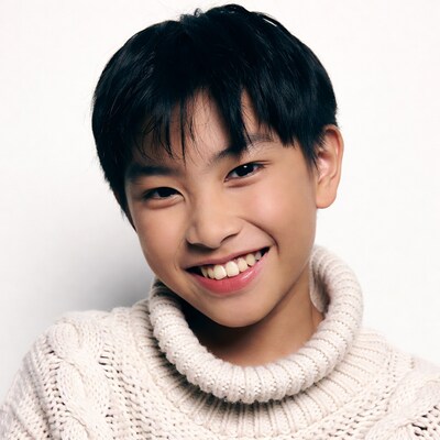 Asian boy smiling in white turtleneck