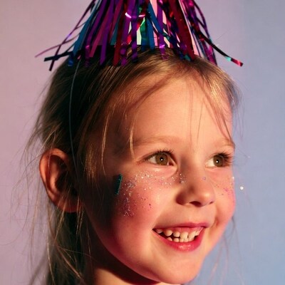 Girl wearing party hat with glitter