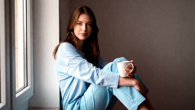 Woman holding coffee mug by window