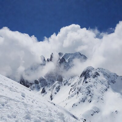 Snowy Mountains with Clouds and Blue Sky
