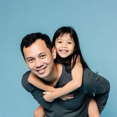 Asian father piggybacking smiling daughter