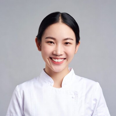 Asian woman smiling in white chef uniform