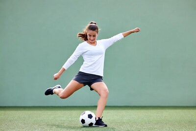 Girl kicking soccer ball