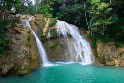 Waterfall cascading into turquoise pool