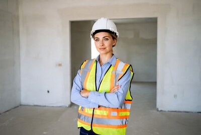 Woman in hard hat and vest in construction site