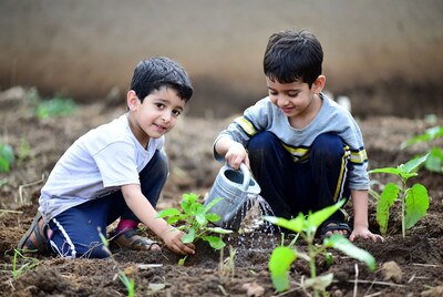 Boys watering plants in garden