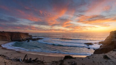 Sunset over beach cove with cliffs