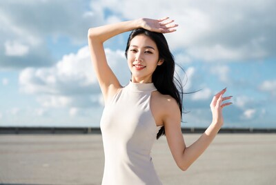 Asian woman posing with arms raised