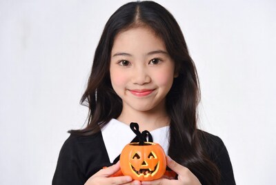 Asian girl holding jack-o-lantern