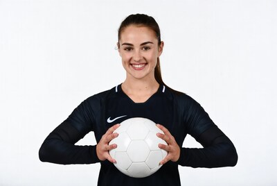 Girl holding soccer ball in Nike jersey
