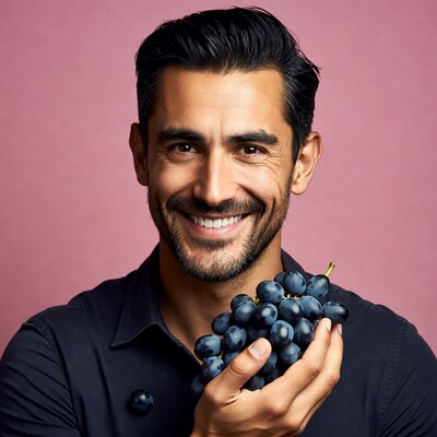 Handsome man holding grapes