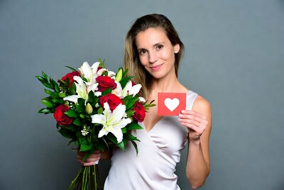 Woman holding roses lilies and heart card